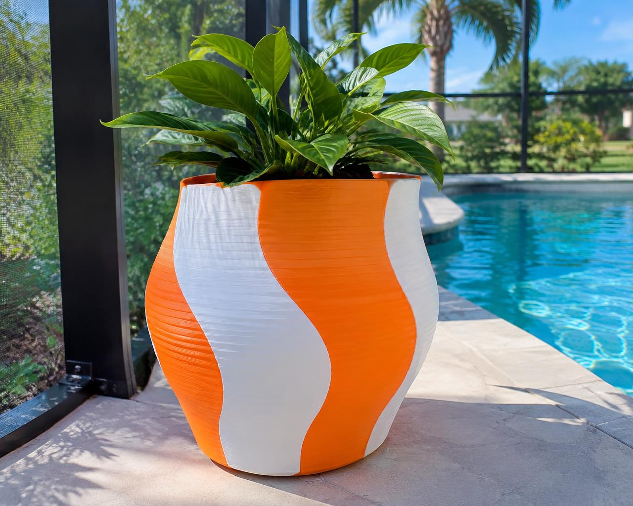 A large orange and white 3D-printed planter on a pool deck